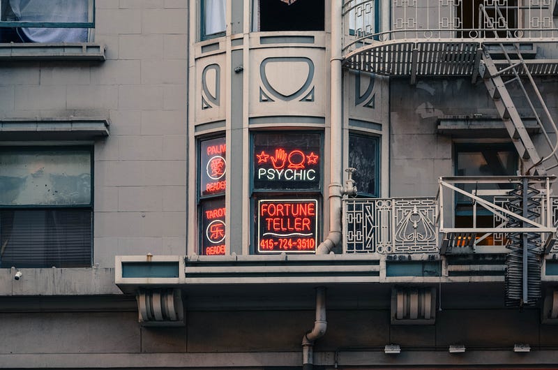 A shot of a building window with Psychic and Fortune Teller written on neon signs.
